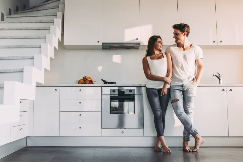 Young couple standing in their new home kitchen.