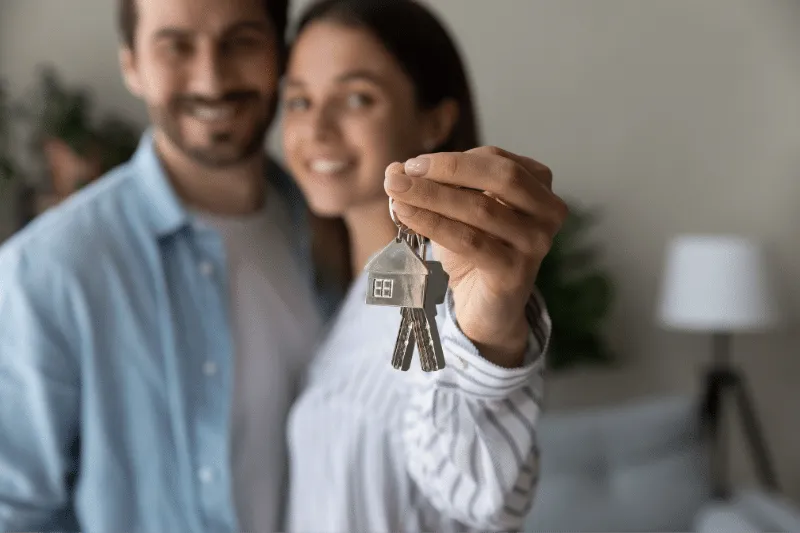 Young couple with their home keys.