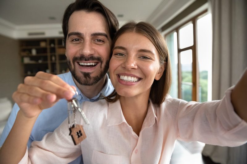 Happy couple with keys of their new home.