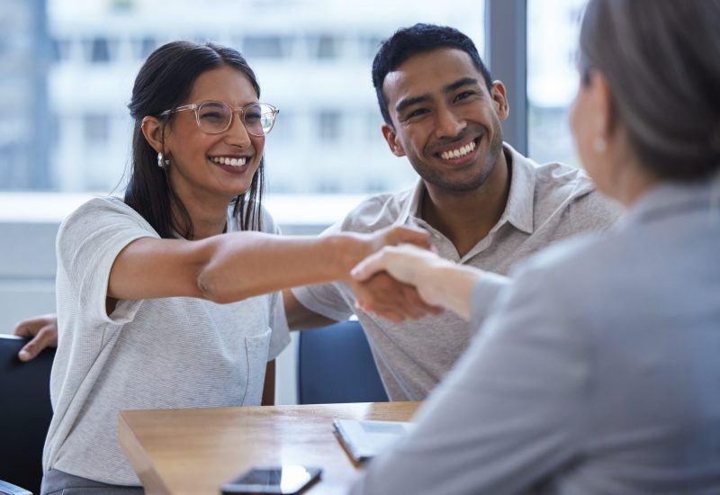 Young couple shaking hands with a consultant.