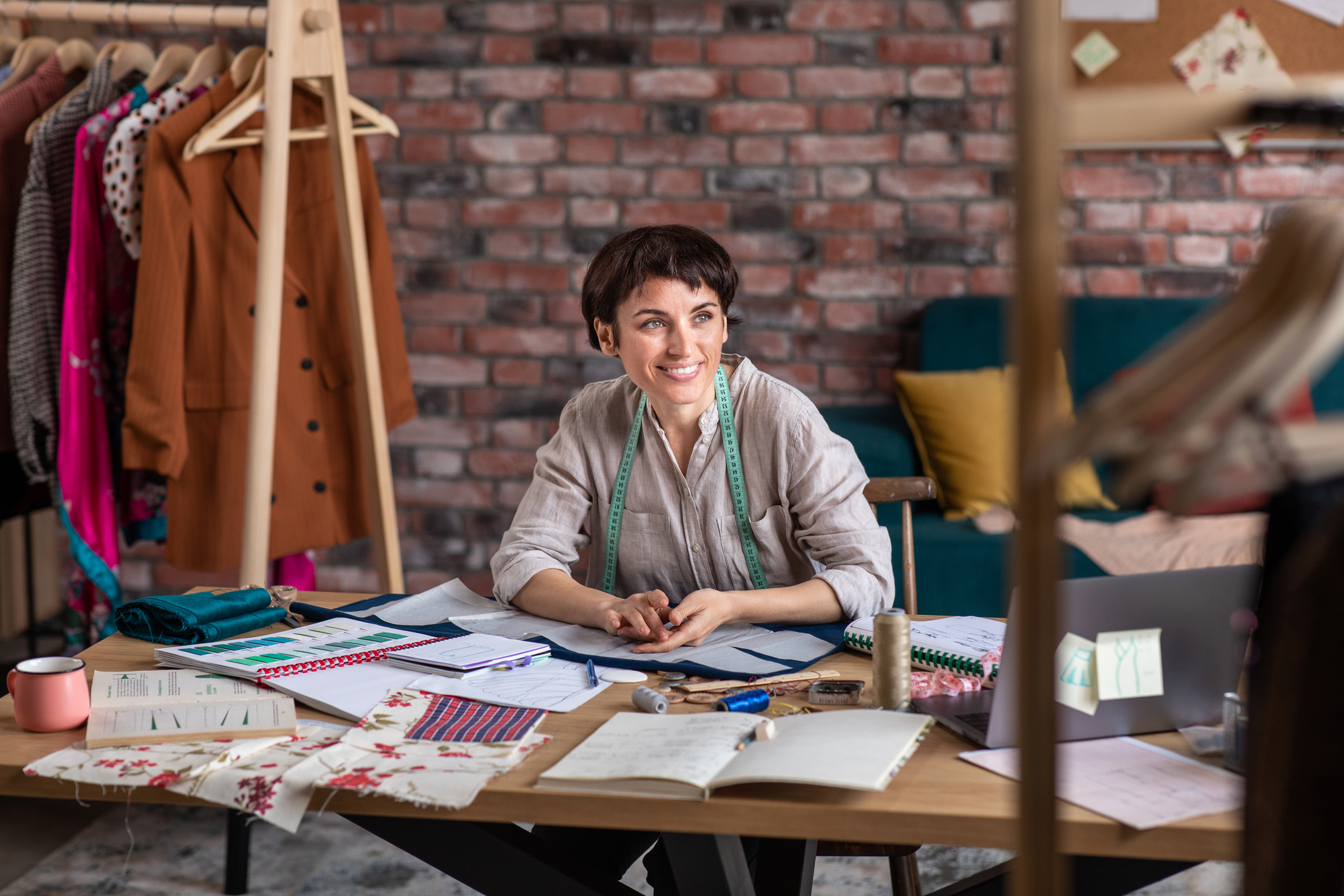 Female designer of clothes seating at her desk.